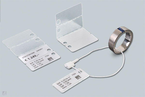 Anwendung von Sicherheitsfaeden bei selbstklebenden Faden-Etiketten vom Typ WrapTag bei der Auszeichnung von Schmuck Anwendung von Sicherheitsfaeden bei selbstklebenden Schmuck-Etiketten vom Typ WrapTag